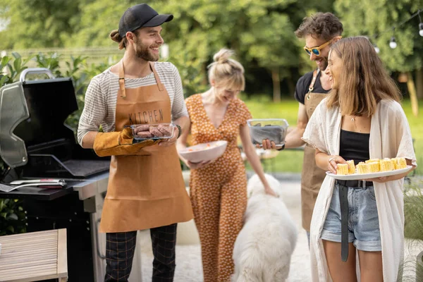 Vänner som lagar mat på grill utomhus — Stockfoto