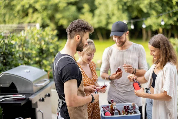 Friends with fridge full of alcohol at party outdoors — Stock Photo, Image