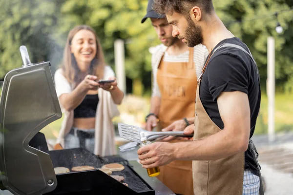 Happe friends cooking on a grill at backyard — Stock Photo, Image