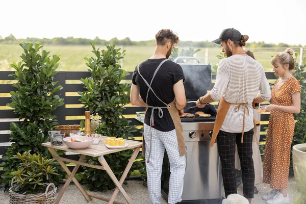 Jongeren grillen voedsel in de achtertuin — Stockfoto