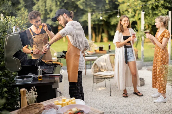 Gençler yemek pişiriyor ve arka bahçede eğleniyor. — Stok fotoğraf