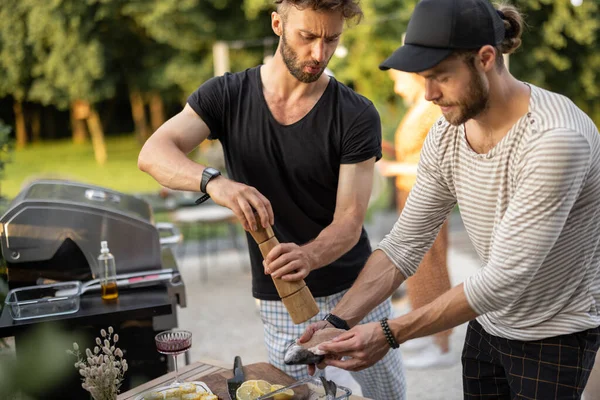 Man koken van vis en groenten op een grill buiten — Stockfoto