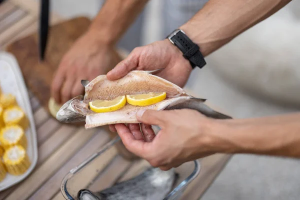 Preparing fresh fish for grilling outdoors — Stock Photo, Image