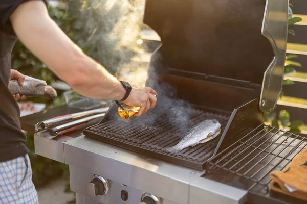 Man cooking fish on a grill — Stock Photo, Image