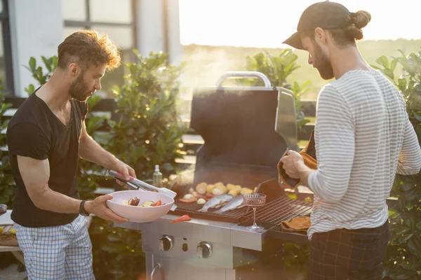 Guy grilling at backyard on a sunset — Stock Photo, Image