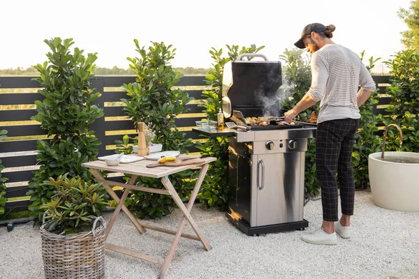 Muž vaří na grilu venku — Stock fotografie