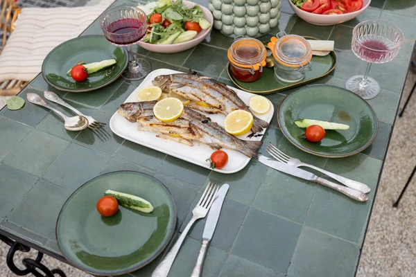 Dışarıdaki yeşil masada ızgara balık. — Stok fotoğraf