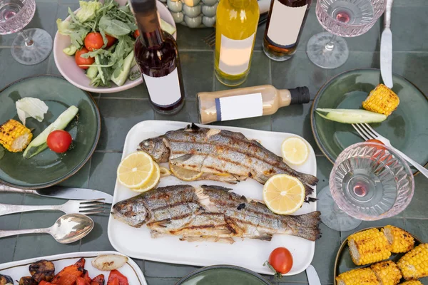 Cibo grigliato e alcol sul tavolo verde — Foto Stock