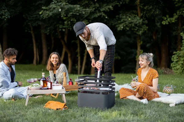 Vrienden samen op de picknick met barbecue en wijn — Stockfoto