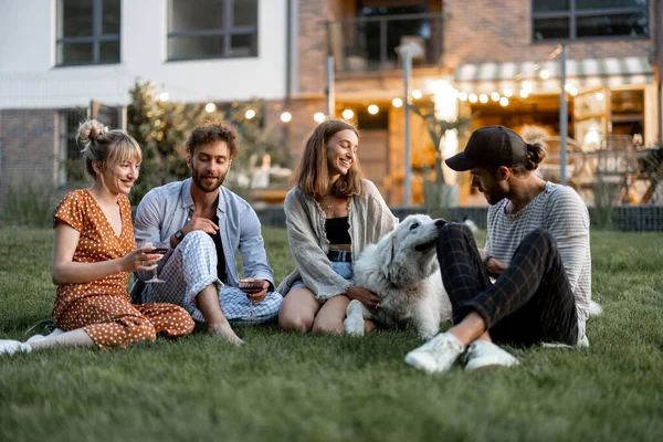 Vänner som har kul på bakgården på kvällen — Stockfoto