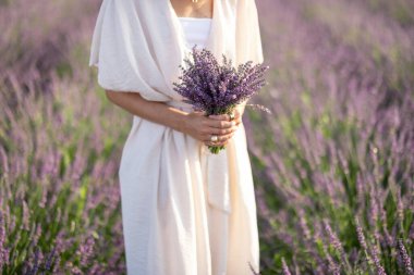 Çiçek açan lavanta tarlasında elinde buket