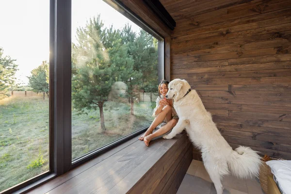 Kobieta cieszyć się przyrodą w wiejskim domu ze zwierzakiem — Zdjęcie stockowe