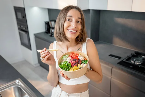 Portret van een gelukkige vrouw met gezonde kom in de keuken — Stockfoto