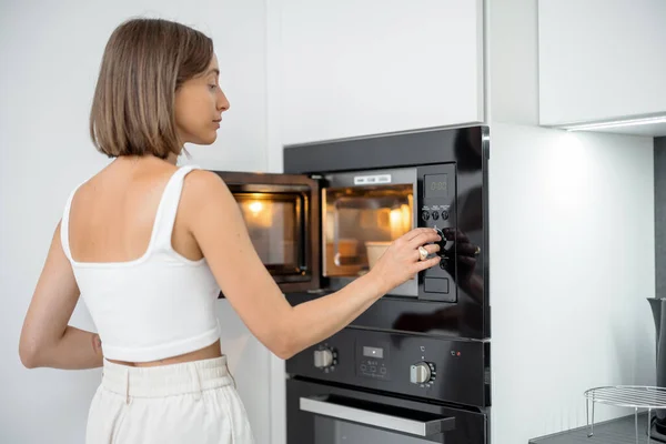 Mulher aquecimento de alimentos com máquina de microondas — Fotografia de Stock