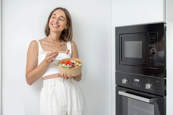 Mulher com comida takeaway na cozinha moderna em casa — Fotografia de Stock