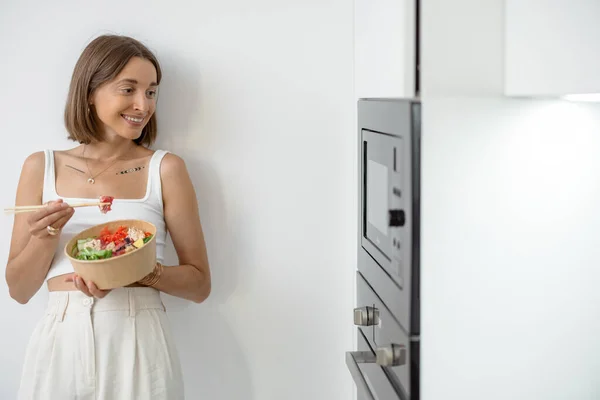 Vrouw met afhaalmaaltijden op de moderne keuken thuis — Stockfoto