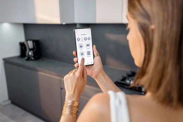 Smart Devices mit Telefon in der Küche steuern — Stockfoto