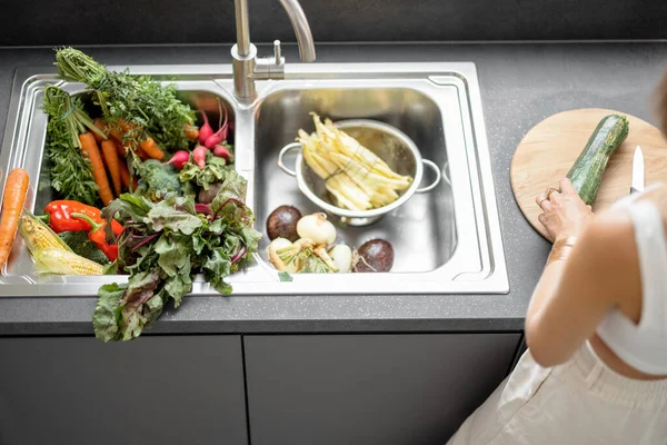 Mulher cozinhar com legumes frescos e verduras na pia — Fotografia de Stock