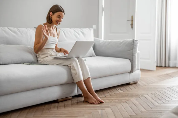 Žena mluví online, sedí doma na gauči — Stock fotografie
