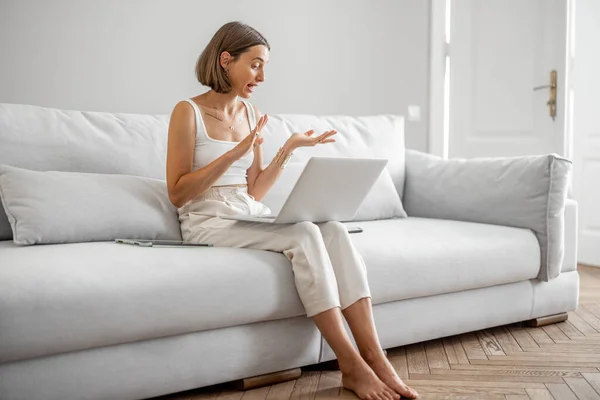 Žena mluví online, sedí doma na gauči — Stock fotografie
