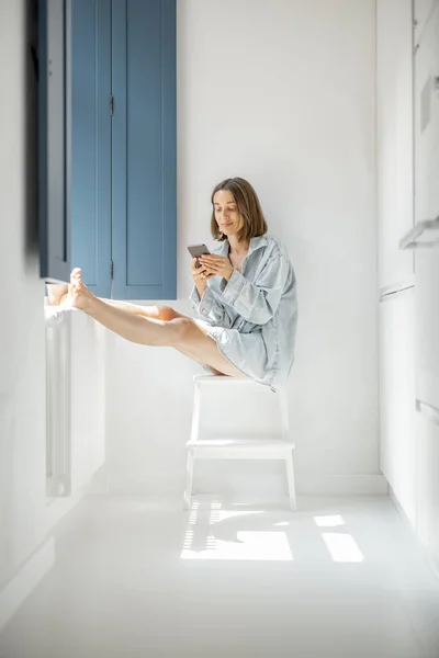 Mujer sentada sola junto a la ventana en casa — Foto de Stock