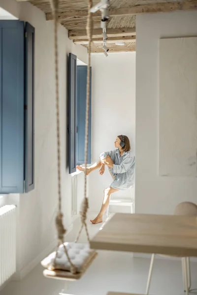 Wanita duduk sendirian di dekat jendela di rumah — Stok Foto