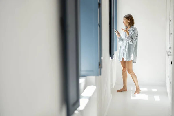 Kvinne kommuniserer på telefon hjemme – stockfoto