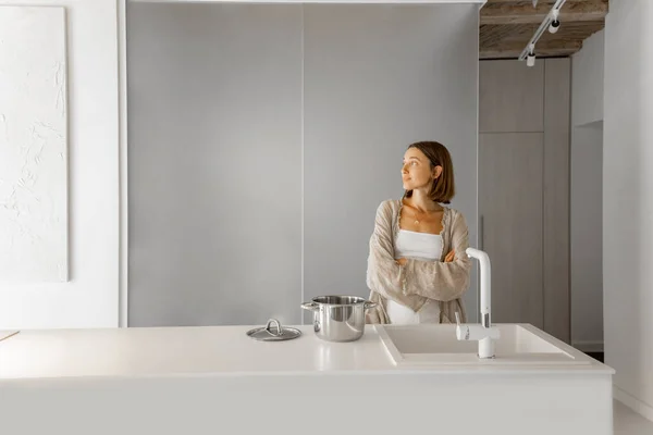 Nainen modernissa valkoisessa keittiössä kotona — kuvapankkivalokuva