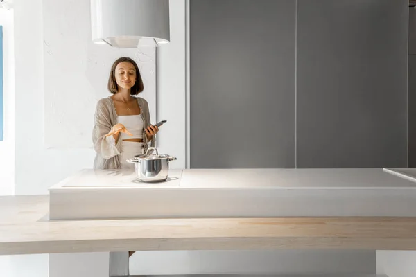 Kobieta gotowanie na płycie elektrycznej w nowoczesnej kuchni — Zdjęcie stockowe