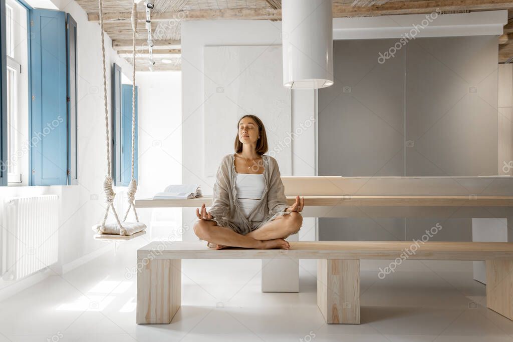 Woman meditates at modern home