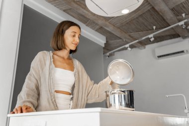 Modern mutfakta yemek pişiren kadın.