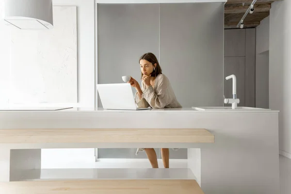 Kvinna med laptop i modernt kök hemma — Stockfoto