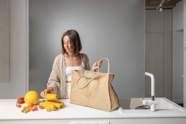 Evdeki modern mutfakta çiğ gıda malzemeleri olan bir kadın.