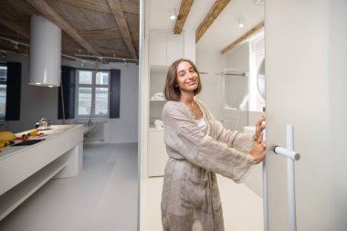 Modern, rahat stüdyo dairede bir kadın.