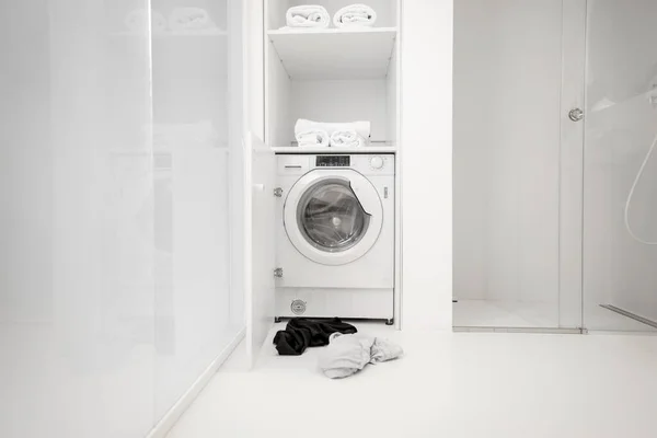 Machine à laver avec des vêtements à la salle de bain — Photo
