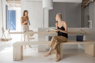 Modern stüdyo dairede kahvaltı saatinde lezbiyen çift.