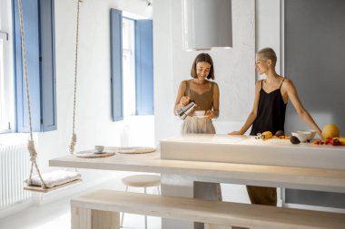 Lezbiyen çift evde kahvaltı hazırlıyor.