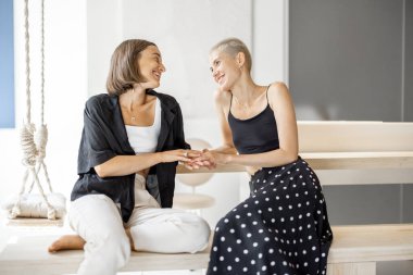 Lezbiyen çift evde konuşuyor ve sarılıyor.