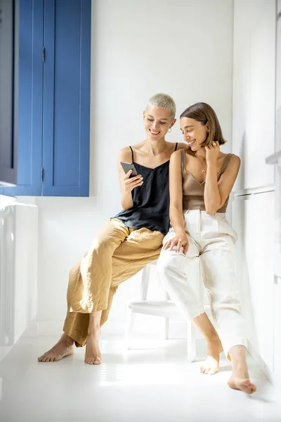 Lesbisches Paar mit Handy zu Hause — Stockfoto