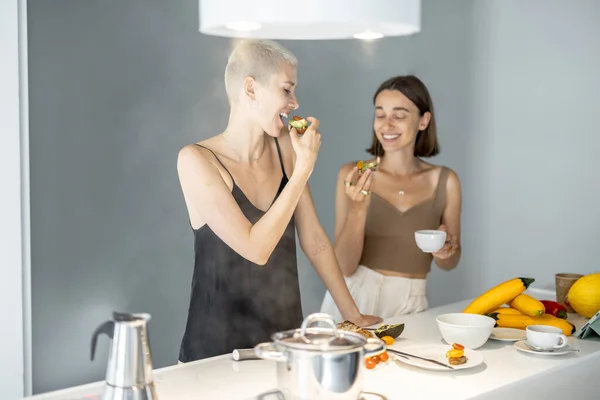 レズビアンカップル食べる朝食でキッチン — ストック写真