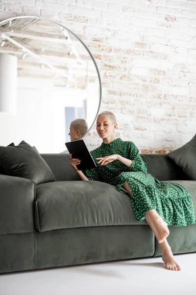 Mujer con estilo con tableta digital en el sofá en casa — Foto de Stock