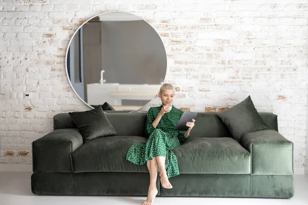 Mujer con estilo con tableta digital en el sofá en casa —  Fotos de Stock