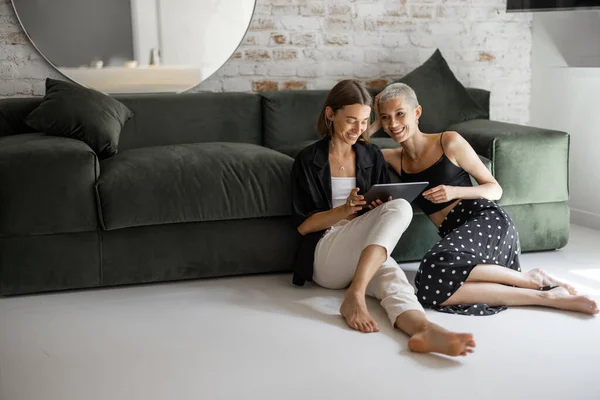 Pareja lesbiana con una tableta digital — Foto de Stock