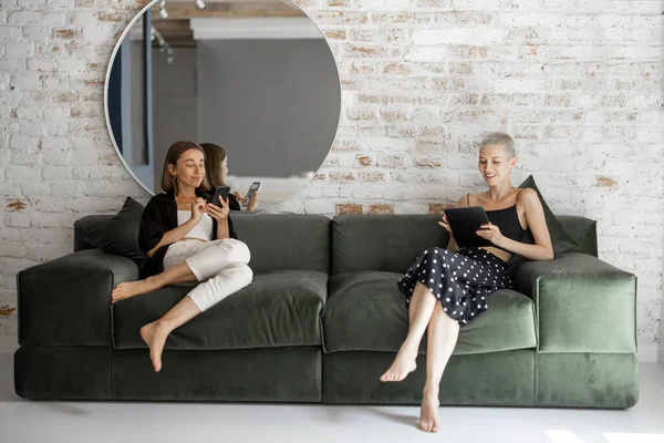 Mujeres con dispositivos digitales en casa — Foto de Stock