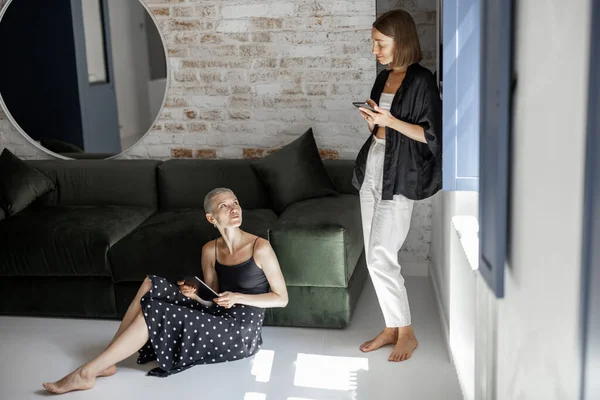 Mujeres con dispositivos digitales en casa — Foto de Stock