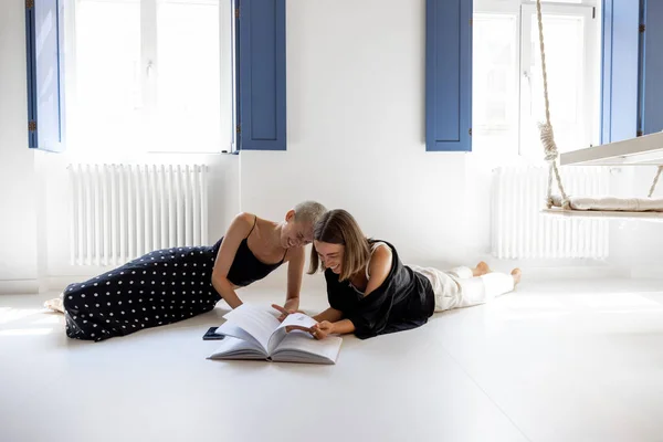 Lesbianas pareja leyendo libro en casa — Foto de Stock