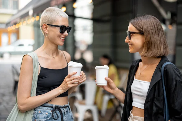Stilvolles weibliches Paar mit Kaffeetasse im Freien — Stockfoto