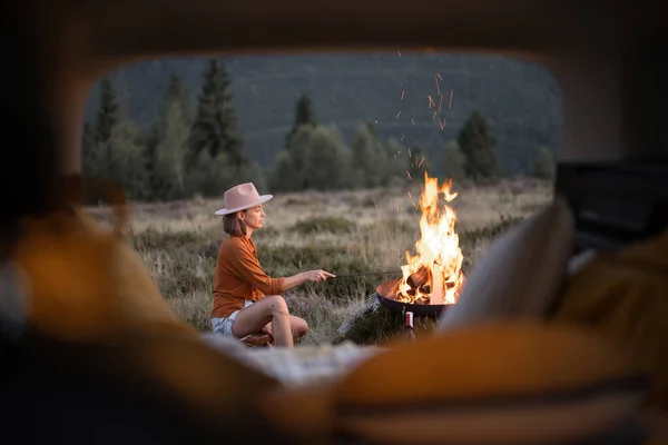 Femme au pique-nique avec feu de joie dans les montagnes — Photo