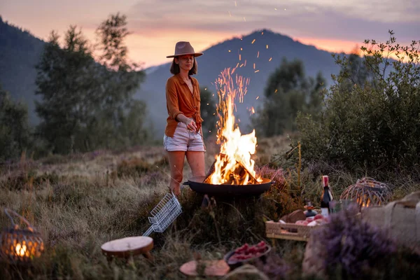 Femme au pique-nique avec feu de joie dans les montagnes — Photo