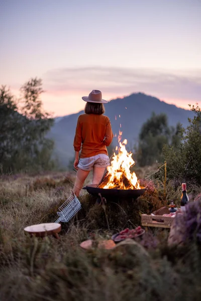 Donna al picnic con falò in montagna — Foto Stock
